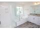 Bright bathroom featuring a soaking tub, glass enclosed shower, granite counters, and a large window at 8692 Acadia Pkwy # 591, Sherrills Ford, NC 28673
