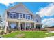 Charming two-story home with a landscaped yard, stone accents, and inviting front porch with rocking chairs at 8692 Acadia Pkwy # 591, Sherrills Ford, NC 28673