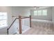 Well-lit staircase leads to an open landing area with large windows and neutral carpeting at 8692 Acadia Pkwy # 591, Sherrills Ford, NC 28673