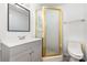 Bathroom featuring a stall shower with gold frame, gray vanity and white toilet at 875 Marys Grove Rd, Cherryville, NC 28021