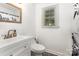 Clean bathroom with a vanity, modern toilet, and a window for natural light at 875 Marys Grove Rd, Cherryville, NC 28021