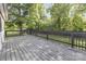 Wood deck with black railing overlooking a private backyard surrounded by mature trees and greenery at 875 Marys Grove Rd, Cherryville, NC 28021