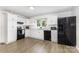 Bright kitchen features white cabinets, black appliances, and laminate flooring at 875 Marys Grove Rd, Cherryville, NC 28021