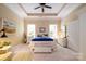 Comfortable bedroom featuring a tray ceiling, ceiling fan, and large bright windows at 8818 Artesa Mill Ln, Charlotte, NC 28214