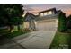 Charming two-story home with a two car garage and landscaped front yard against a warm sunset at 8818 Artesa Mill Ln, Charlotte, NC 28214