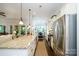 Open kitchen with granite countertops, a stainless steel refrigerator, and a view of the living area at 8818 Artesa Mill Ln, Charlotte, NC 28214