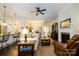 Open-concept living room with a ceiling fan, fireplace, and seamless flow into the kitchen at 8818 Artesa Mill Ln, Charlotte, NC 28214