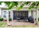 Covered outdoor patio with table and chairs surrounded by lush landscaping at 8818 Artesa Mill Ln, Charlotte, NC 28214