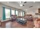 Living room with leather couches, a dark wood coffee table, a ceiling fan, and view into the dining room at 1033 Dorsey Dr, Fort Mill, SC 29715