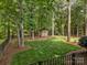 Landscaped backyard featuring mature trees, a storage shed, and an open grassy area at 104 Golden Bell Ct, Mooresville, NC 28117