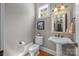 Cozy bathroom with pedestal sink, toilet, and window at 104 Golden Bell Ct, Mooresville, NC 28117