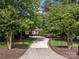 View of the long driveway leading up to the home with mature trees and landscaping around the property at 104 Golden Bell Ct, Mooresville, NC 28117