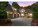 Charming Tudor-style home boasts three-car garage, beautiful stone accents, and a manicured front yard at 104 Golden Bell Ct, Mooresville, NC 28117