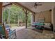 Covered outdoor patio featuring comfortable seating, ceiling fan, and backyard views at 104 Golden Bell Ct, Mooresville, NC 28117