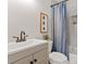Bathroom featuring a sink with a framed mirror, a toilet, and a bathtub with a shower and blue-patterned curtain at 1096 Palmyra Dr, Tega Cay, SC 29708