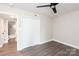 This well-lit bedroom features hardwood floors, a ceiling fan, and a closet adding modern comfort to this room at 1096 Palmyra Dr, Tega Cay, SC 29708
