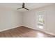 Bright bedroom with hardwood floors and ceiling fan leading to sunroom, creating a peaceful and serene space at 1096 Palmyra Dr, Tega Cay, SC 29708
