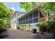 A bright exterior view of a home with a screened porch and well-maintained landscaping at 1096 Palmyra Dr, Tega Cay, SC 29708