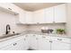 Bright kitchen with white cabinets, granite countertops, stainless steel sink, and modern fixtures at 1096 Palmyra Dr, Tega Cay, SC 29708