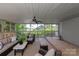 The screened-in porch features stylish furnishings, a ceiling fan, and picturesque views of the water at 1096 Palmyra Dr, Tega Cay, SC 29708