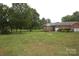 Spacious backyard with brick home, two-car garage, and expansive green lawn at 116 Lanes End Rd, Locust, NC 28097