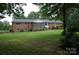 Exterior view of brick home with large backyard, screened in porch, and mature trees at 116 Lanes End Rd, Locust, NC 28097