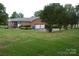Exterior of brick home with 2 car garage and sprawling, manicured backyard lawn at 116 Lanes End Rd, Locust, NC 28097