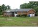 Brick home with attached two-car garage, screened in porch, and lush green yard at 116 Lanes End Rd, Locust, NC 28097
