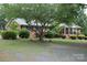 Charming brick home featuring a mature tree and well-manicured landscaping at 116 Lanes End Rd, Locust, NC 28097