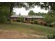 Classic brick home with inviting entrance, mature trees, and a sloping front yard at 116 Lanes End Rd, Locust, NC 28097