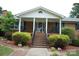 Charming brick home featuring a covered front porch, manicured landscaping, and inviting entryway at 116 Lanes End Rd, Locust, NC 28097