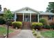 Inviting front porch with white columns and brick steps leading to the entrance at 116 Lanes End Rd, Locust, NC 28097