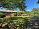 Charming brick home featuring a well-manicured lawn, mature trees, and a welcoming front porch at 116 Lanes End Rd, Locust, NC 28097