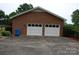 Two-car detached brick garage with white doors and ample parking space at 116 Lanes End Rd, Locust, NC 28097