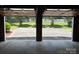 View from inside garage shows concrete floor extending to concrete drive and lawn beyond at 116 Lanes End Rd, Locust, NC 28097