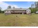 Wide backyard view of the home with solar panels and a ground-level deck at 1230 Long Creek Ln, Salisbury, NC 28146