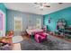 Bright bedroom featuring blue wallpaper, a ceiling fan, and a cozy pink accent chair and bed at 1230 Long Creek Ln, Salisbury, NC 28146