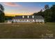Charming one-story home featuring a welcoming front porch and lush, sprawling lawn at sunset at 1230 Long Creek Ln, Salisbury, NC 28146