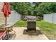 Backyard featuring a grill, outdoor dining table and chairs, privacy fence and mature tree line at 12408 Savannah Cottage Dr, Charlotte, NC 28273