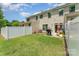 Spacious backyard with green lawn, white fence, grill, outdoor furniture, and exterior of home at 12408 Savannah Cottage Dr, Charlotte, NC 28273