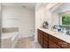 Spacious bathroom featuring double sinks, tile floors, soaking tub, and a large mirror at 12408 Savannah Cottage Dr, Charlotte, NC 28273