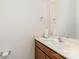 Cozy half bath featuring a wood vanity, white sink, chrome faucet, and decorative mirror at 12408 Savannah Cottage Dr, Charlotte, NC 28273