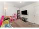 Bedroom with pink toys, tv, and plenty of light at 12408 Savannah Cottage Dr, Charlotte, NC 28273