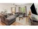 Inviting living room with a large sectional sofa, ceiling fan, and bright natural light at 12408 Savannah Cottage Dr, Charlotte, NC 28273