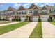 Charming townhomes featuring attached garages, manicured lawns, and stylish exterior finishes at 12408 Savannah Cottage Dr, Charlotte, NC 28273