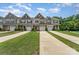 Charming townhomes featuring attached garages, manicured lawns, and stylish exterior finishes at 12408 Savannah Cottage Dr, Charlotte, NC 28273