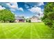 Picture-perfect backyard with manicured lawn, mature trees, and charming architecture; great for outdoor gatherings at 1305 Yellowood Ct, Rock Hill, SC 29732