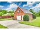 Charming brick garage with an automatic door, side entry, and adjacent driveway, surrounded by lush greenery at 1305 Yellowood Ct, Rock Hill, SC 29732