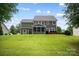 A spacious backyard with a screened porch, lush lawn, and green exterior home at 132 Flora Vista Dr, Mooresville, NC 28117