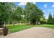Lush backyard featuring a stone paver patio, mature trees, and a view of the lake at 132 Flora Vista Dr, Mooresville, NC 28117
